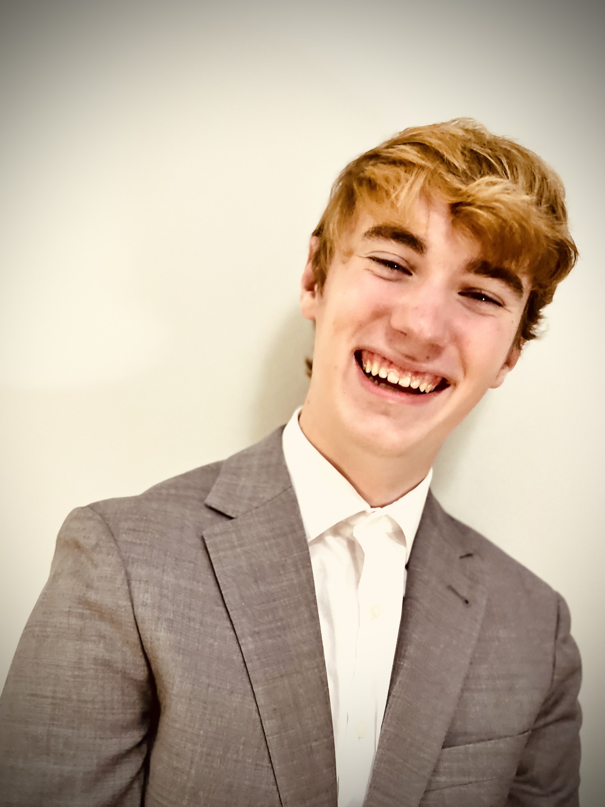 Michael Miller smiling brightly, leaning to one side, and laughing